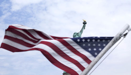 Low angle view of american flag against cloudy sky