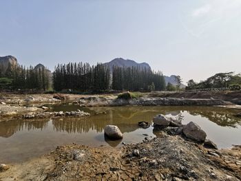 Rocks in lake against clear sky