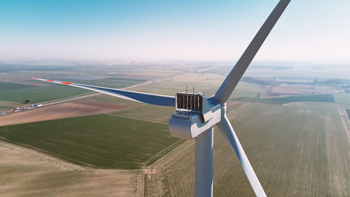 Aerial view of close up windmill turbine in countryside area, wind power and renewable energy