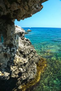 Rock formation in sea against sky