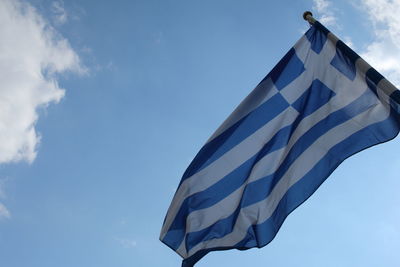 Low angle view of flag against blue sky