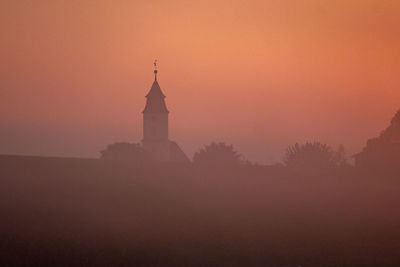 Silhouette of building against sky during sunset