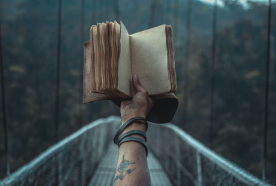 Close-up of hand holding railing against blurred background