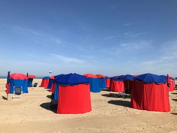 Multi colored umbrellas on beach against blue sky