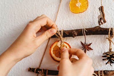 Woman hands decorating handmade craft christmas tree. sustainable christmas, zero waste,.