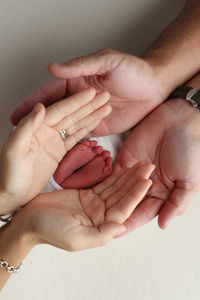 Cropped hand of person gesturing against wall