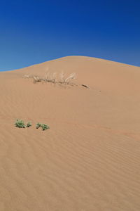 Scenic view of desert against clear blue sky