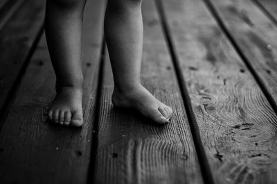 Low section of child standing on hardwood floor