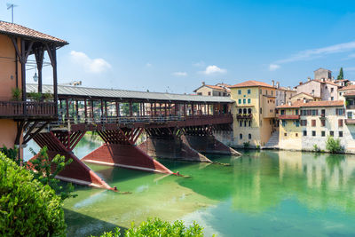 Arch bridge over river against buildings in city