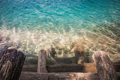 High angle view of wooden posts in sea