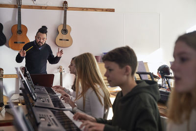 Teenagers attending keyboard lesson