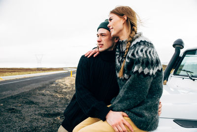 Young couple kissing against the sky