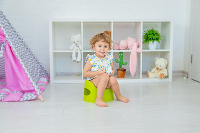 Portrait of cute girl playing with toys on floor