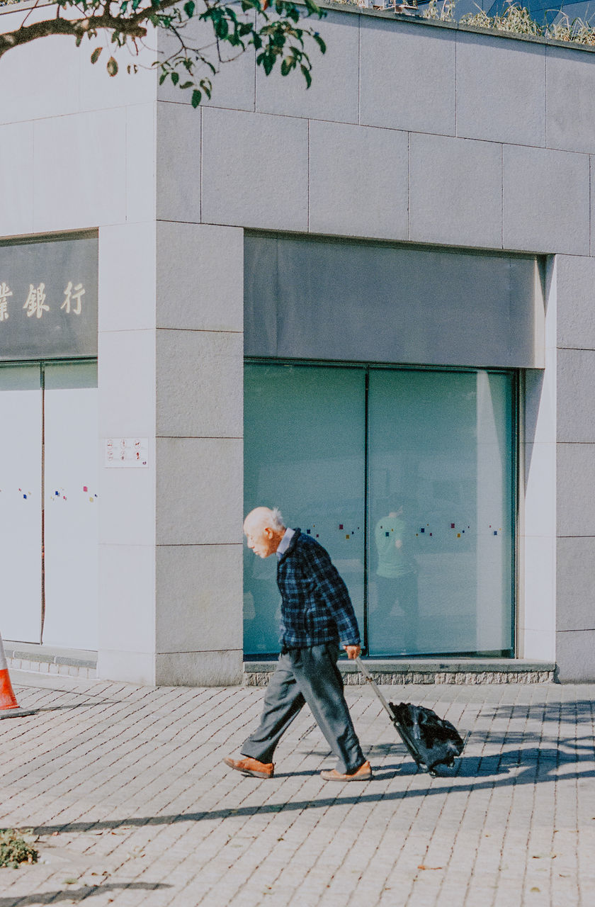 architecture, building exterior, one person, built structure, full length, real people, casual clothing, men, lifestyles, leisure activity, building, day, footpath, walking, city, males, side view, street, nature, outdoors