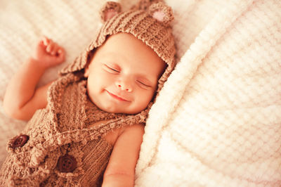 Smiling newborn baby lying on bed