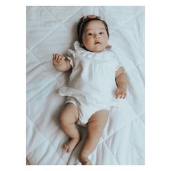 Portrait of cute baby boy lying on bed