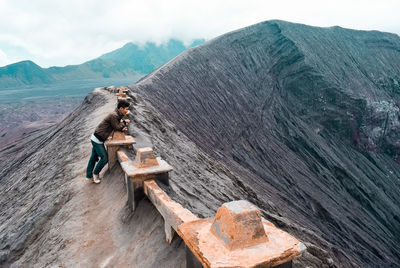 Side view of man on mountain against sky