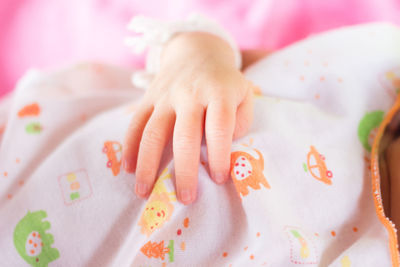 Cropped hand of child on textile