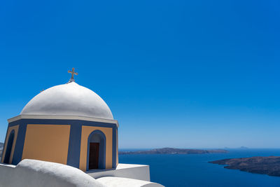 Ocher and blue dome of an orthodox church in thira, santorini island, greece.