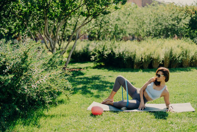 Woman sitting on grass in garden