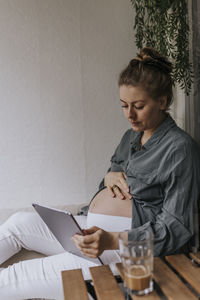 Pregnant woman using digital tablet