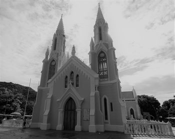 Low angle view of bell tower against cloudy sky