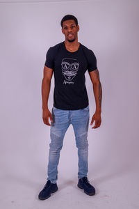 Portrait of young man standing against wall