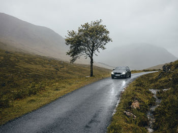 Car driving on road through glen etive