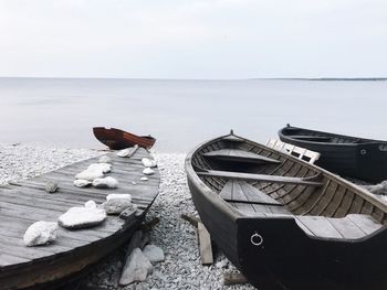 Boats moored at beach against sky