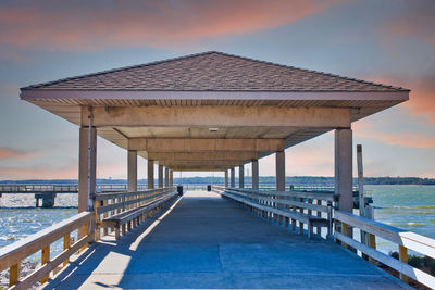 Pier over sea against sky during sunset