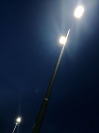 Low angle view of illuminated lights against sky at night