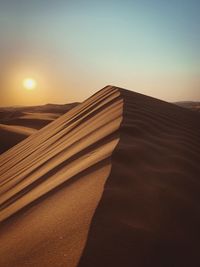 Scenic view of desert against sky during sunset