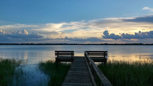 Jetty over lake against sky during sunset