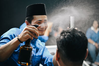 Barber cutting hair of customer at salon