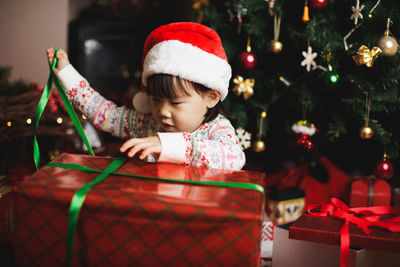 Girl unboxing christmas present at home