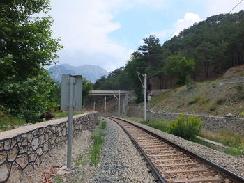 Railroad tracks by trees against sky