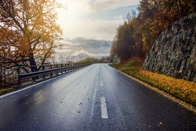 Road amidst trees against sky