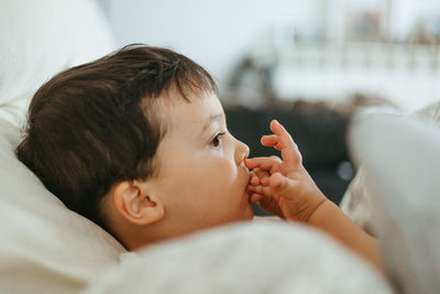 Close-up of cute baby girl sleeping on bed at home