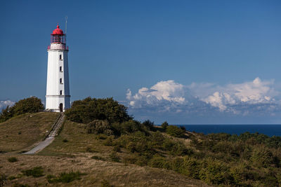 Lighthouse by sea against sky