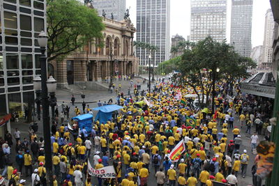 High angle view of crowd by historic building during parade in city