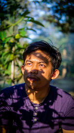 Portrait of young man looking away outdoors