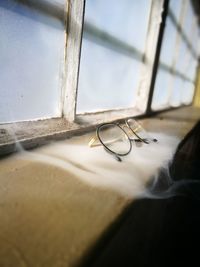 Close-up of eyeglasses on window sill at home