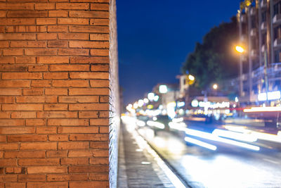 Illuminated street amidst buildings in city at night