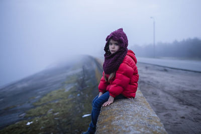 Full length of woman on rock against sky during winter