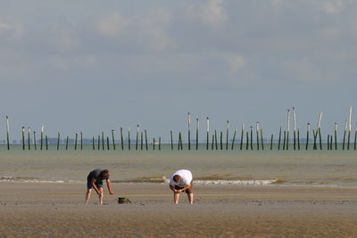 Friends standing on shore at beach