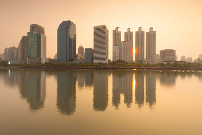 Reflection of buildings in city at sunset