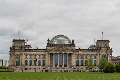 Facade of building against cloudy sky