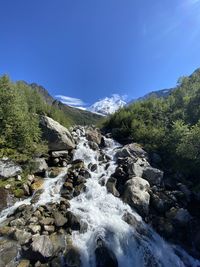 Scenic view of waterfall against sky