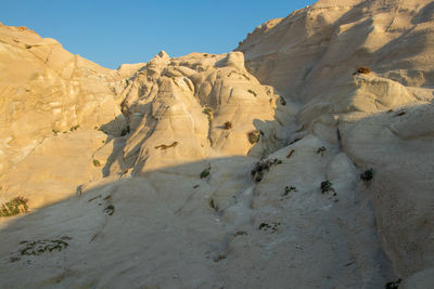 Low angle view of rocky mountains against clear sky