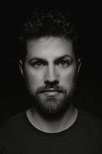 Close-up portrait of young man against black background